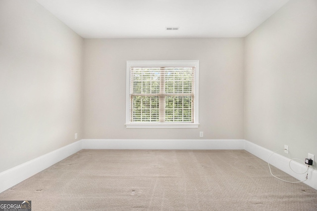 empty room featuring carpet flooring and baseboards