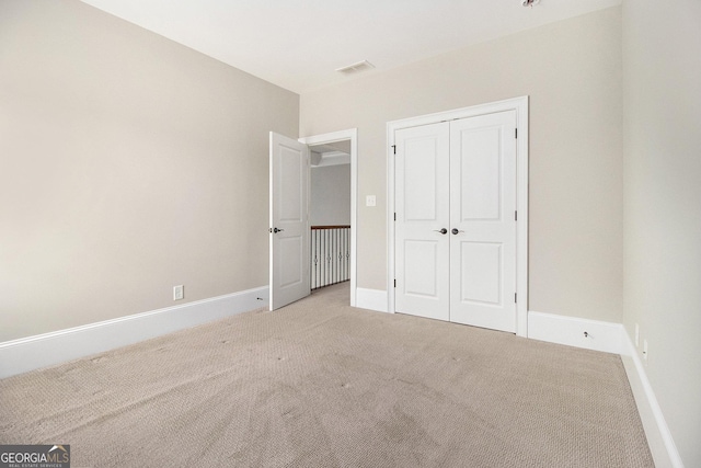 unfurnished bedroom with carpet flooring, baseboards, and a closet