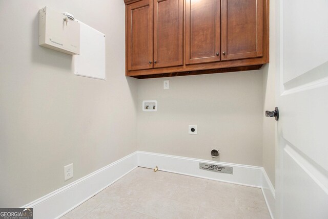 washroom with hookup for a washing machine, cabinet space, tile patterned floors, and baseboards