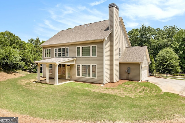 rear view of house with driveway, a lawn, a chimney, a shingled roof, and an attached garage