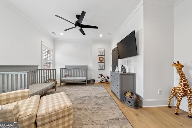 bedroom featuring crown molding, ceiling fan, and light hardwood / wood-style flooring