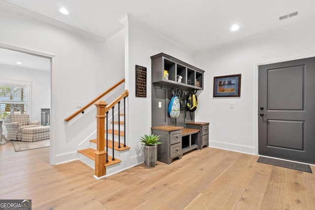 mudroom with ornamental molding and light hardwood / wood-style floors