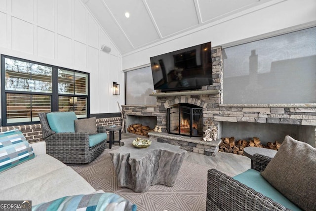 living room featuring a stone fireplace and high vaulted ceiling