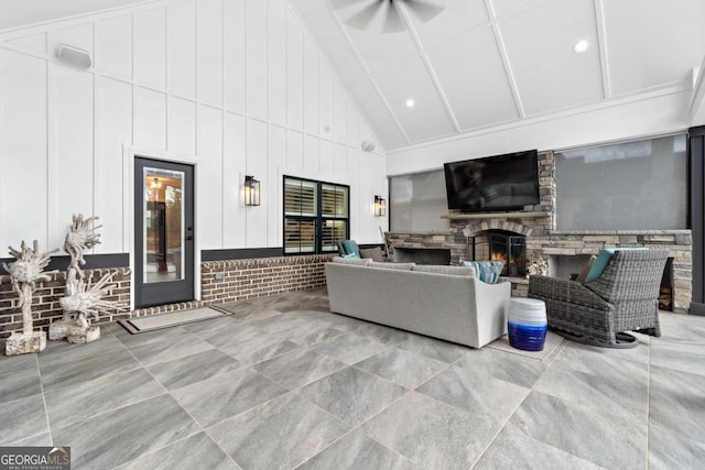 living room with a stone fireplace and high vaulted ceiling