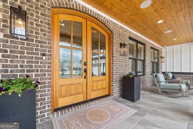 doorway to property featuring a porch and french doors