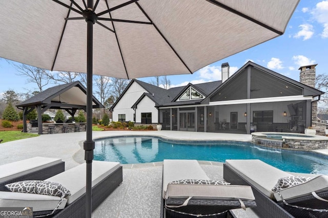 view of pool with an outdoor bar, a gazebo, a patio area, a sunroom, and an in ground hot tub