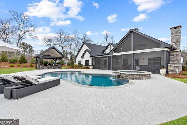 view of pool featuring a gazebo, a patio area, a sunroom, pool water feature, and an in ground hot tub