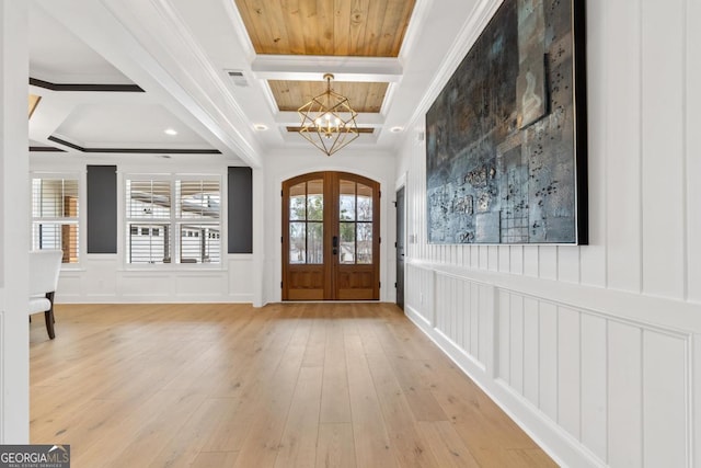 entrance foyer with coffered ceiling, crown molding, light hardwood / wood-style flooring, and french doors