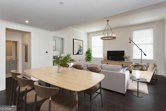 dining space featuring a notable chandelier, crown molding, and dark wood-type flooring