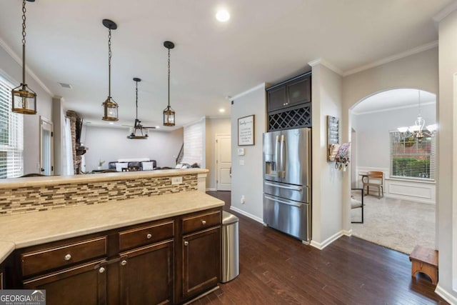 kitchen featuring stainless steel refrigerator with ice dispenser, ornamental molding, backsplash, and pendant lighting