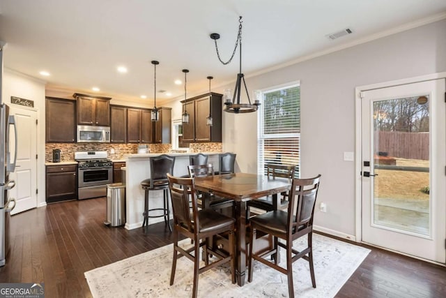 dining room with crown molding and dark hardwood / wood-style flooring