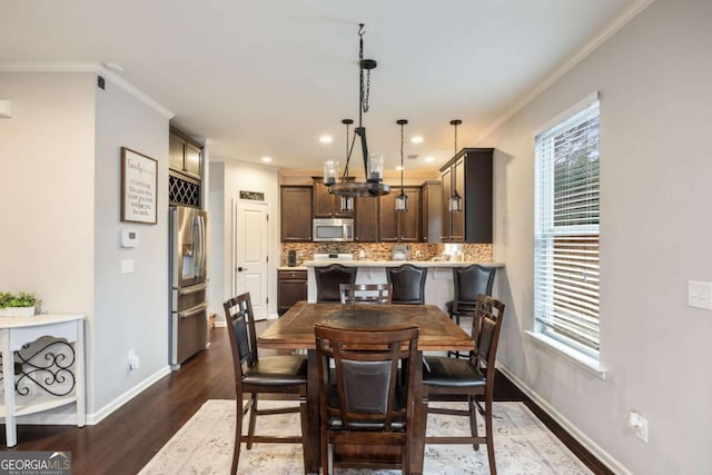 dining area with ornamental molding, dark wood-type flooring, and a wealth of natural light