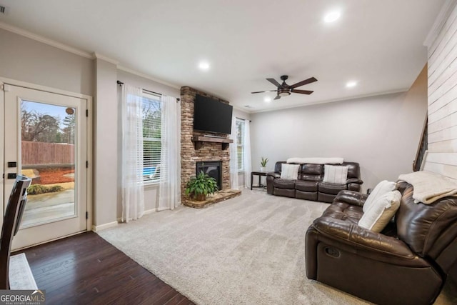 living room featuring crown molding, ceiling fan, a fireplace, and dark hardwood / wood-style flooring