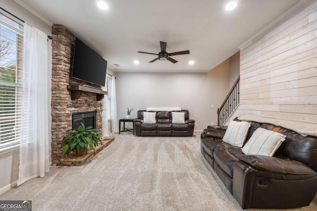 living room with crown molding, a fireplace, a healthy amount of sunlight, and carpet flooring