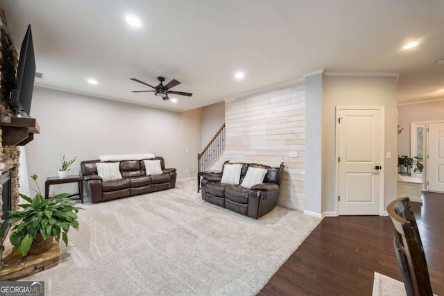 living room with crown molding, ceiling fan, a fireplace, and hardwood / wood-style floors