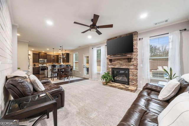 carpeted living room with crown molding, plenty of natural light, and a fireplace