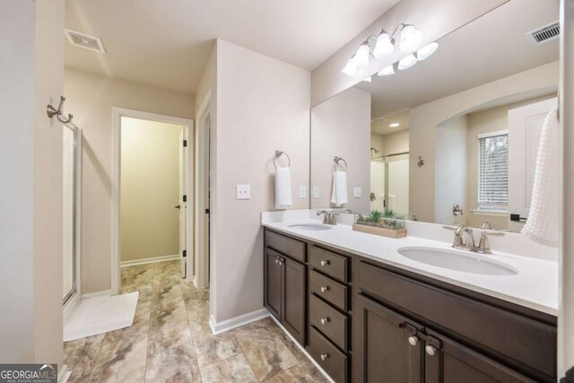 bathroom featuring vanity and a shower with door