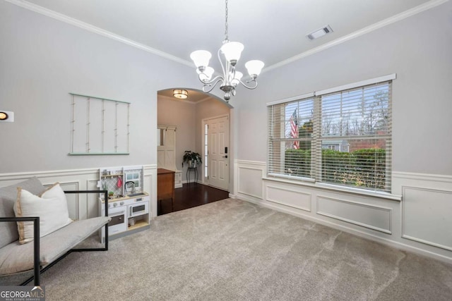 sitting room featuring crown molding, carpet flooring, and a notable chandelier