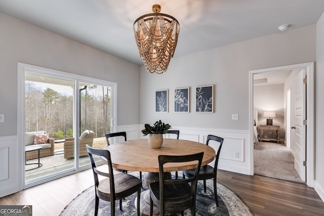 dining area featuring wood-type flooring and a notable chandelier