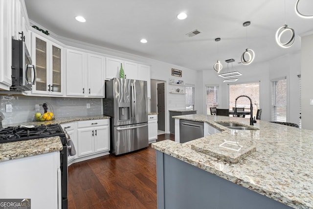 kitchen with stainless steel appliances, a sink, white cabinets, dark wood finished floors, and glass insert cabinets