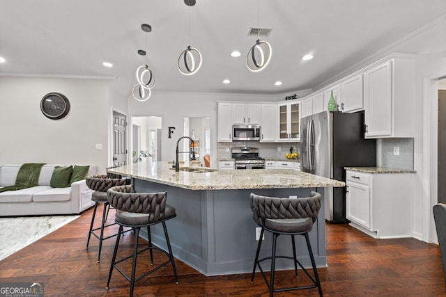 kitchen with appliances with stainless steel finishes, dark wood finished floors, white cabinets, and a sink