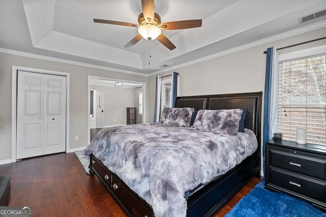 bedroom featuring a raised ceiling, visible vents, baseboards, and dark wood-style flooring