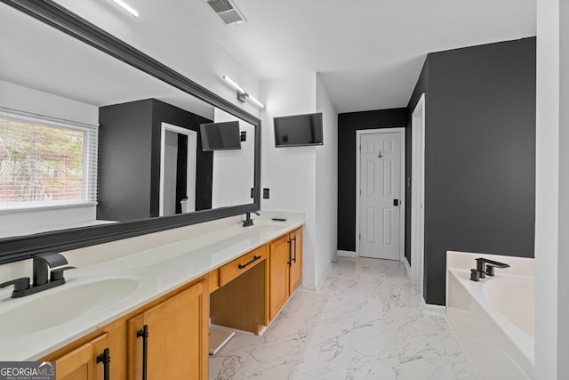 bathroom with marble finish floor, a garden tub, a sink, and visible vents