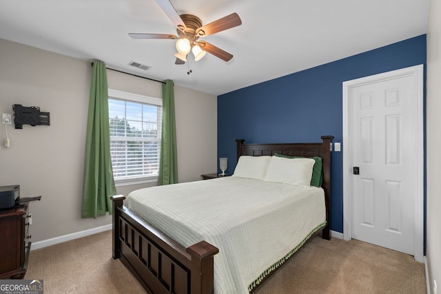 carpeted bedroom featuring a ceiling fan, visible vents, and baseboards