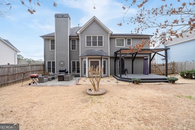 back of property featuring a patio, a fenced backyard, a chimney, an outdoor hangout area, and a deck