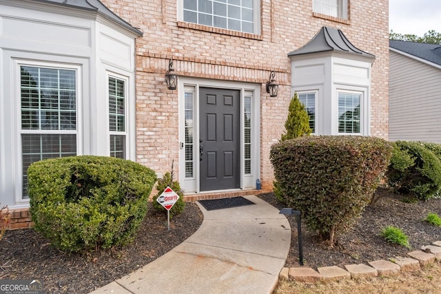 property entrance featuring brick siding