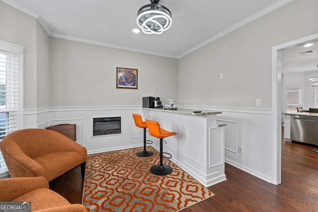 interior space featuring a glass covered fireplace, visible vents, stainless steel dishwasher, and wood finished floors