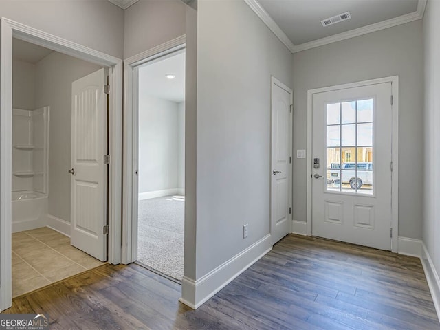 foyer entrance featuring ornamental molding and wood-type flooring