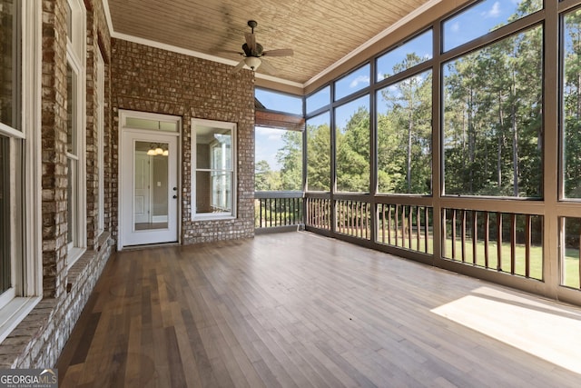 unfurnished sunroom featuring wood ceiling and ceiling fan