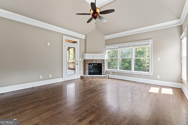 unfurnished living room featuring wood-type flooring, lofted ceiling, ornamental molding, ceiling fan, and a brick fireplace