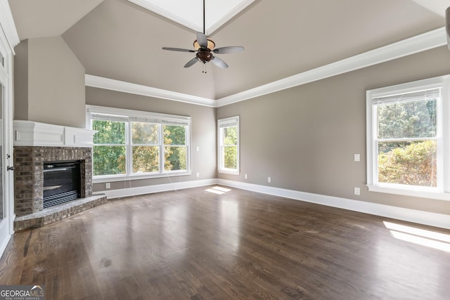 unfurnished living room with crown molding, vaulted ceiling, a brick fireplace, ceiling fan, and hardwood / wood-style floors