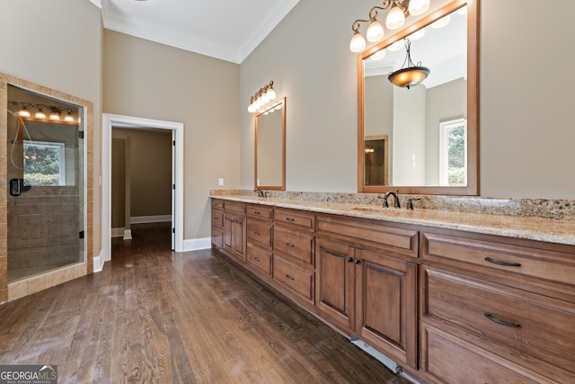 bathroom with hardwood / wood-style flooring, ornamental molding, vanity, and an enclosed shower