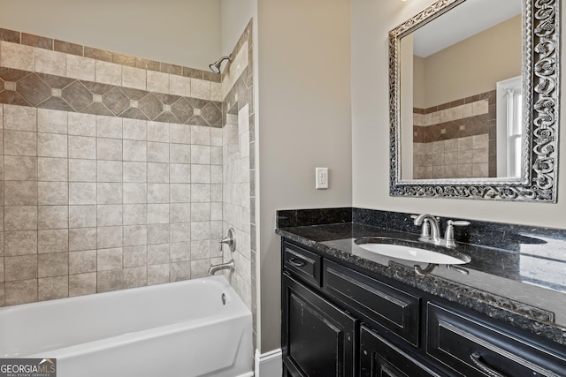 bathroom featuring tiled shower / bath and vanity