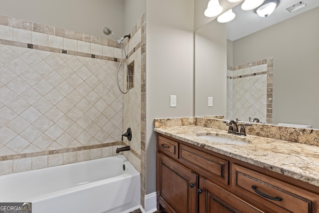 bathroom featuring vanity and tiled shower / bath