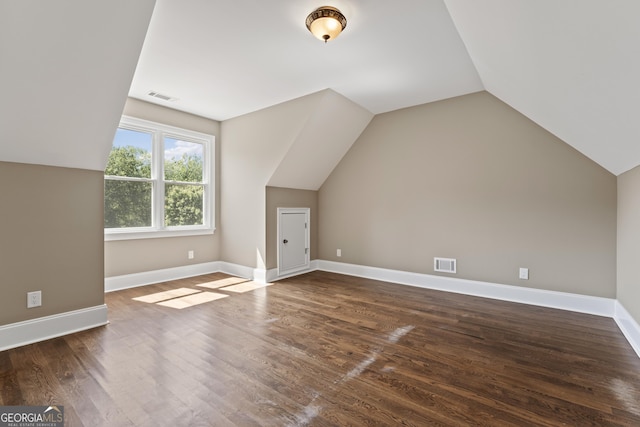 additional living space featuring lofted ceiling and dark hardwood / wood-style flooring