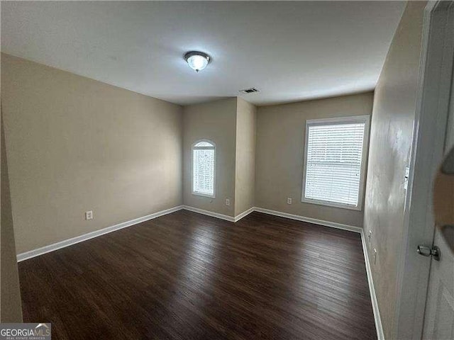 unfurnished room with dark hardwood / wood-style flooring