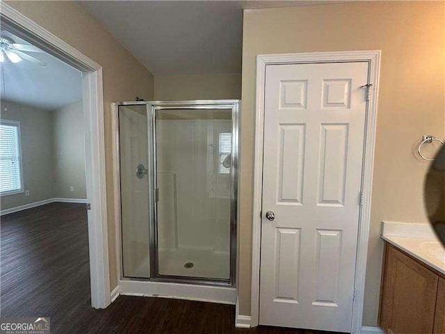 bathroom featuring hardwood / wood-style flooring, vanity, ceiling fan, and walk in shower