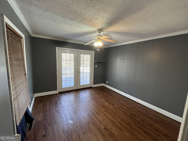 empty room with crown molding, ceiling fan, a textured ceiling, dark hardwood / wood-style flooring, and french doors