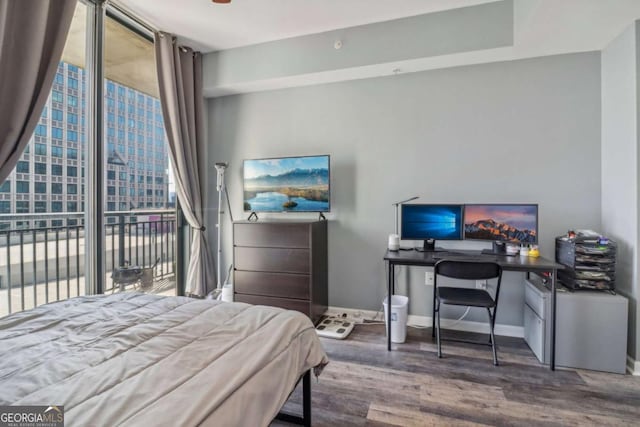 bedroom featuring expansive windows, hardwood / wood-style floors, and access to exterior