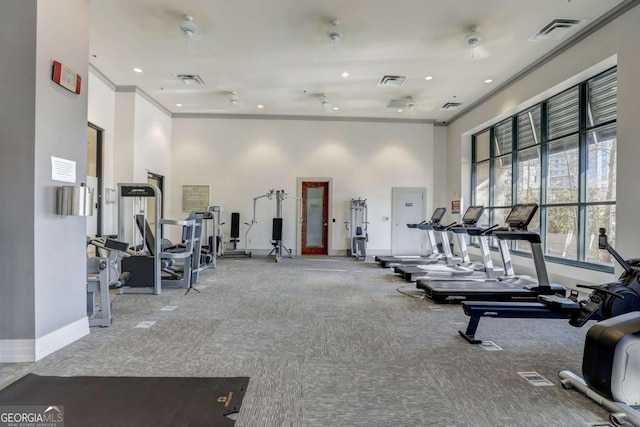 workout area with a high ceiling, crown molding, and carpet floors