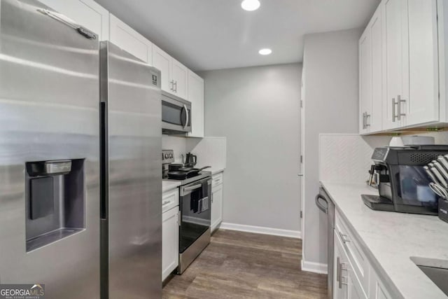 kitchen featuring appliances with stainless steel finishes, dark hardwood / wood-style floors, light stone countertops, and white cabinets