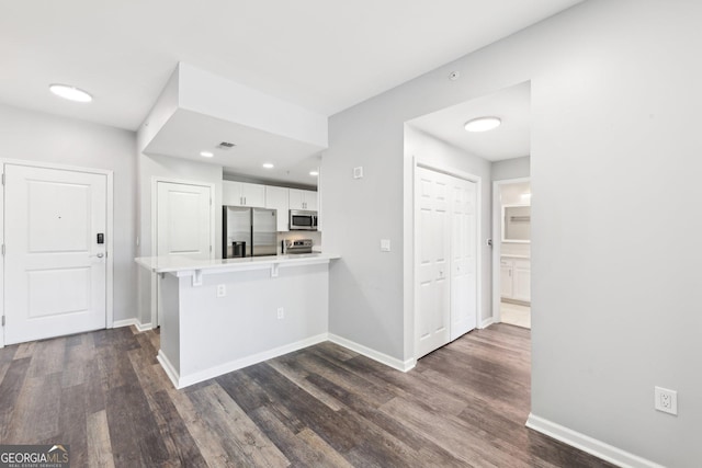3040 Peachtree Rd NW Unit 613, Atlanta, GA 30305 - kitchen featuring stainless steel appliances, white cabinetry, a peninsula, dark wood-style flooring, and light countertops