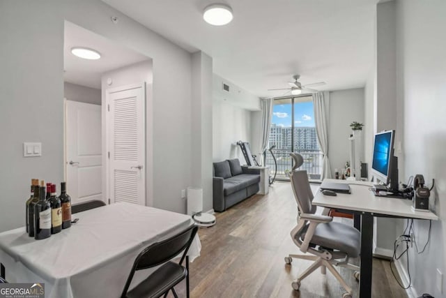 office space featuring hardwood / wood-style flooring, expansive windows, and ceiling fan