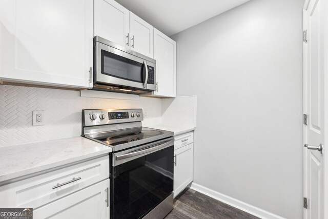 3040 Peachtree Rd NW Unit 613, Atlanta, GA 30305 - kitchen featuring appliances with stainless steel finishes, dark wood-style floors, decorative backsplash, white cabinets, and light stone countertops