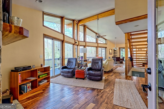 living area featuring wood-type flooring, high vaulted ceiling, ceiling fan, and beam ceiling