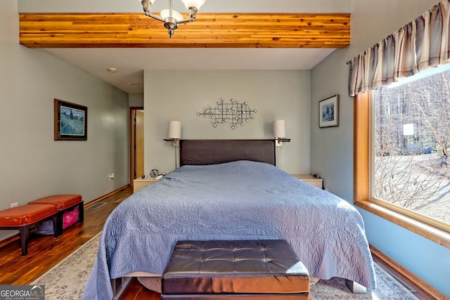 bedroom featuring beam ceiling, baseboards, and wood finished floors